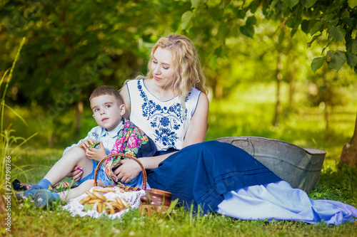 Portrait of Happy Caucasian Mother and Her Little Kid.Posing with Basket Full of Bread Rings Outdoors. photo