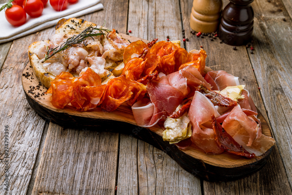 slicing of different meat bacon, jamon, parma, chorizo on the board slicing of different meat bacon, jamon, parma, chorizo on the board