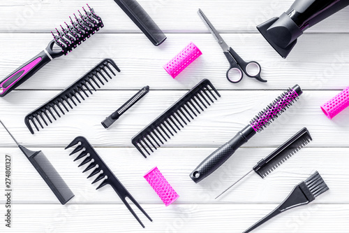 Set of professional hairdresser tools with combs and sciccors on white wooden background top view pattern