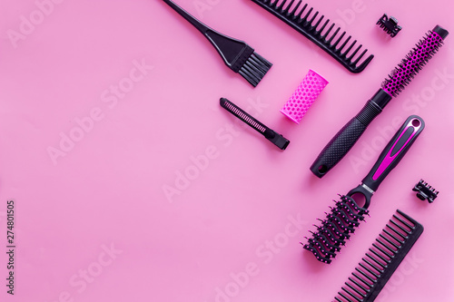 Combs and hairdresser tools in beauty salon work desk on pink background top view mockup