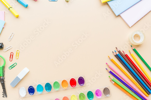 School supplies stationery, paints on pastel orange background, back to school concept with free copy space for text, modern elementary education. Kids desk, flat lay, overhead, top view, mockup.