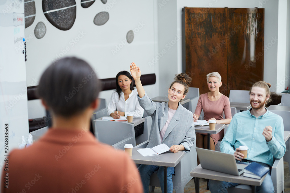 © Seventyfour - Wide angle portrait of contemporary young woman raising hand in class with group of student enjoying lecture, teacher point of view © Seventyfour - Wide angle portrait of contemporary young woman raising hand in class with group of student enjoying lecture, teacher point of view