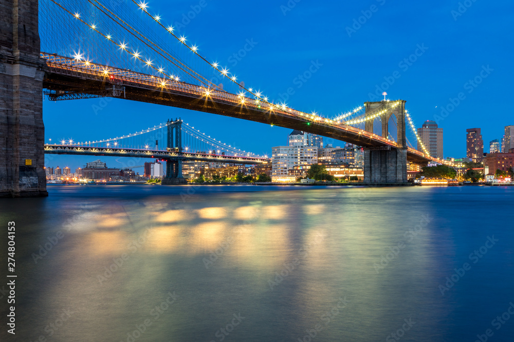 Fototapeta premium Long Exposure Picture of the Brooklyn Bridge Lighted Up At Night