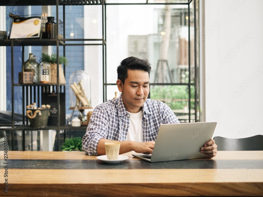 Smart Asian man working with laptop in cafe, work concept and copy space. Smart Asian man working with laptop in cafe, work concept and copy space.