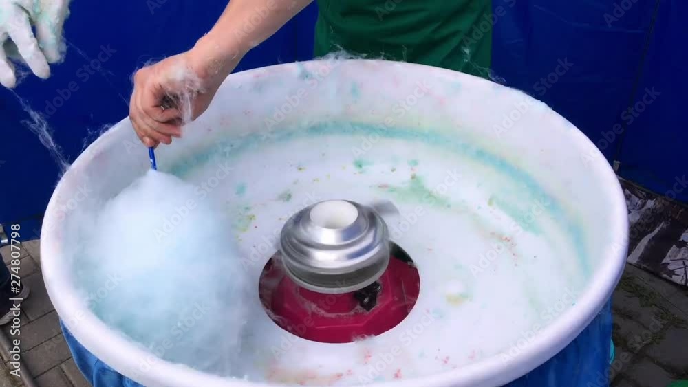Process of making blue sweet cotton candy on a special machine. Process of making blue sweet cotton candy on a special machine.