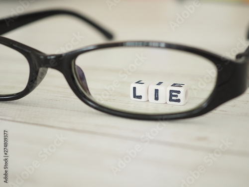 眼鏡のレンズを通して見えるLIEの単語