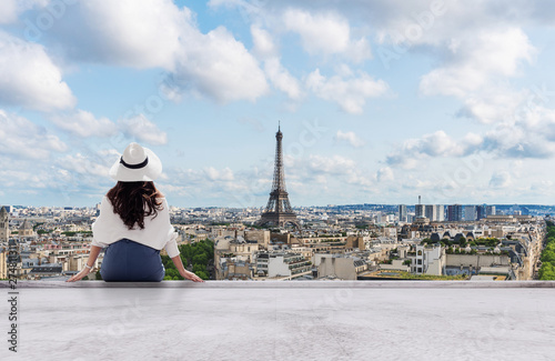 Young traveler woman in white hat looking at Eiffel tower, famous landmark and travel destination in Paris, France in summer © SasinParaksa