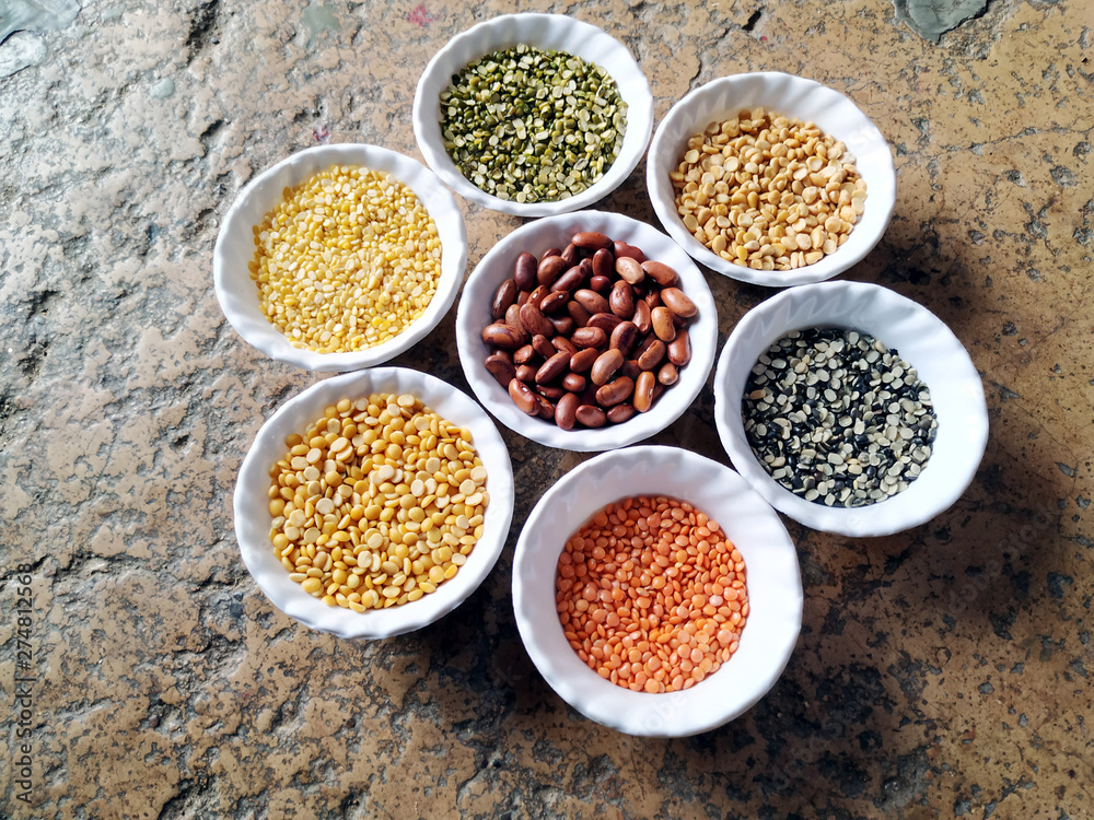 Uncooked pulses,grains and seeds in White bowls over stone background. selective focus