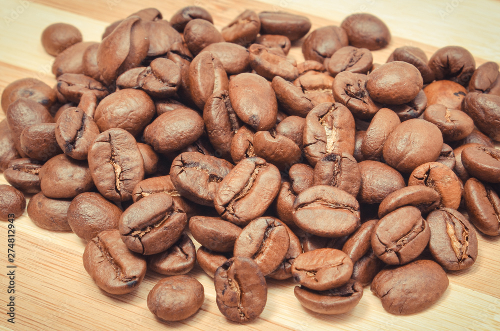 Heap of coffee grains on wooden board Heap of coffee grains on wooden board