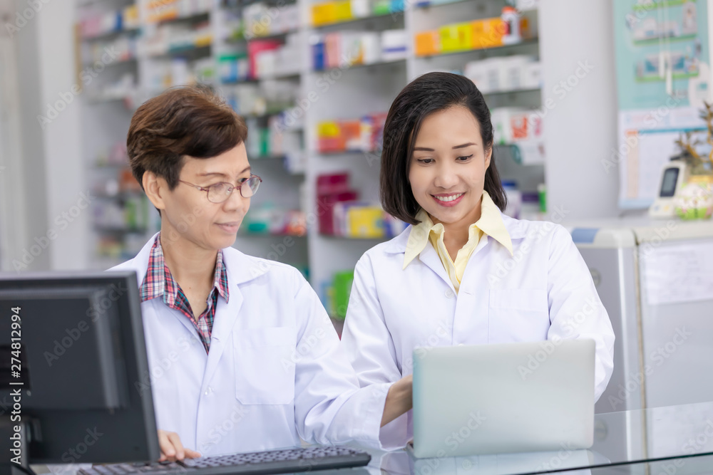 pharmacist are keying drug information on laptop computer pharmacist are keying drug information on laptop computer