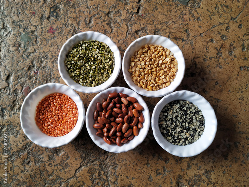 Uncooked pulses,grains and seeds in White bowls over stone background. selective focus