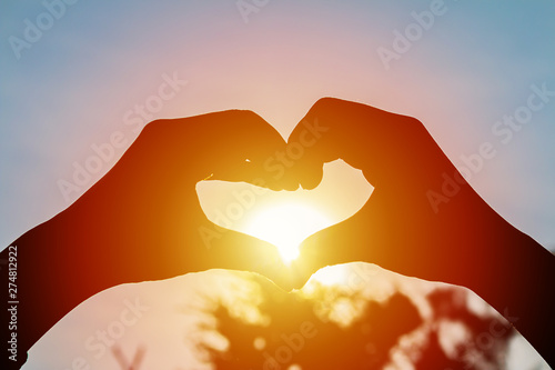 love shape hand silhouette at sunset