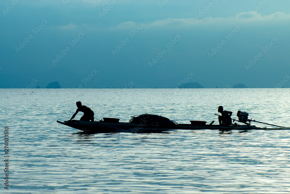 Naklejka premium Silhouette of minimal fishing boat in the blue hour on the lake.