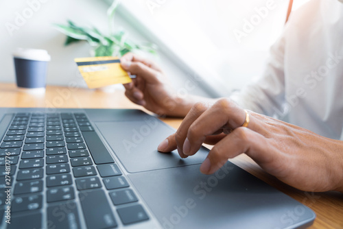 Man paying with credit card and entering security code for online shoping making a payment or purchasing goods on the internet with laptop computer  online shopping concept