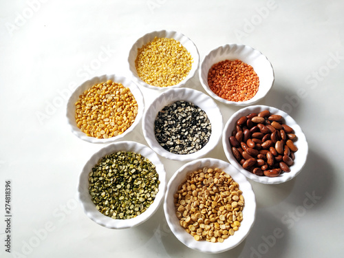 Uncooked pulses,grains and seeds in White bowls over white background. selective focus