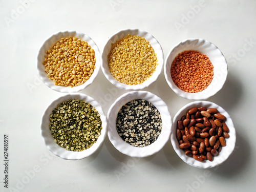 Uncooked pulses,grains and seeds in White bowls over white background. selective focus