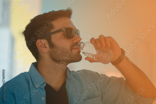 handsome man drinking water from bottom.for a good health.
