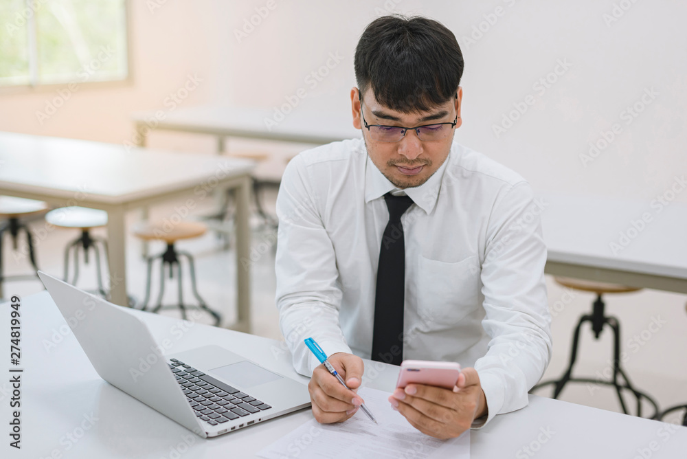 Young business man working at office with laptop, mobile and documents Young business man working at office with laptop, mobile and documents