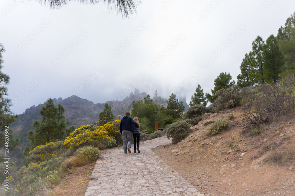 Men and teenage girl  hiking in the mountains in foggy day