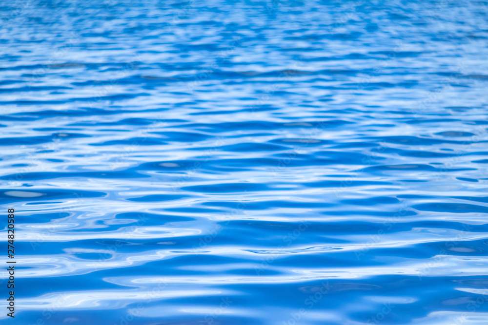 Naklejka premium Water surface. Background image. The concept of recreation at the sea, by the river or lake. Shades of blue, minimalism. The texture of the water surface.