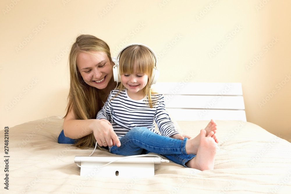 Mother and daughter using tablet together on the bed. Mother and daughter using tablet together on the bed.