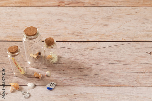 Mini bottle glasses fill with small roll of papers decorate with tiny spiral conche photo