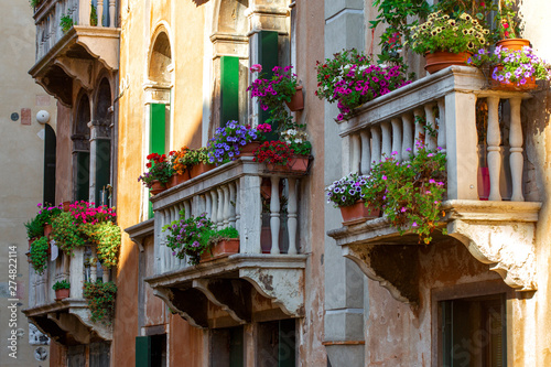 Beautiful building facade with flowers pots in Venice, Italy. Summer cityscape © kucherav