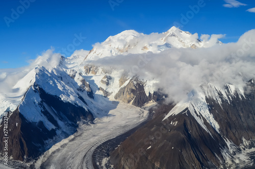 Aerial view of Mount Denali - mt Mckinley peak from a plane with glaciers around and blue sky above. Denali National Park © Czech the World