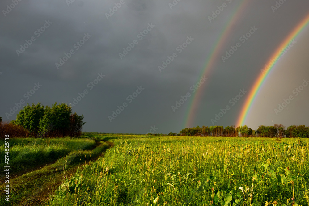 double rainbow in summer after rain in the field. Nature after the rain. double Rainbow double rainbow in summer after rain in the field. Nature after the rain. double Rainbow