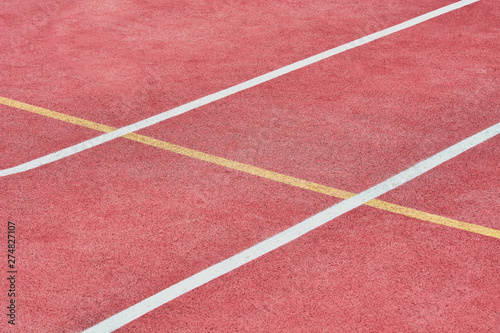 Red tennis court with white and yellow markings on pitch.