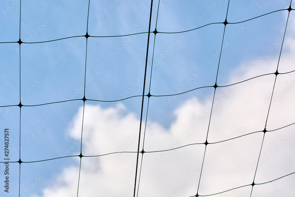 Black volleyball net against the blue sky with clouds. Black volleyball net against the blue sky with clouds.
