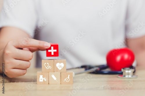 Health Insurance Concept,hand arranging wood block stacking with icon healthcare medical.