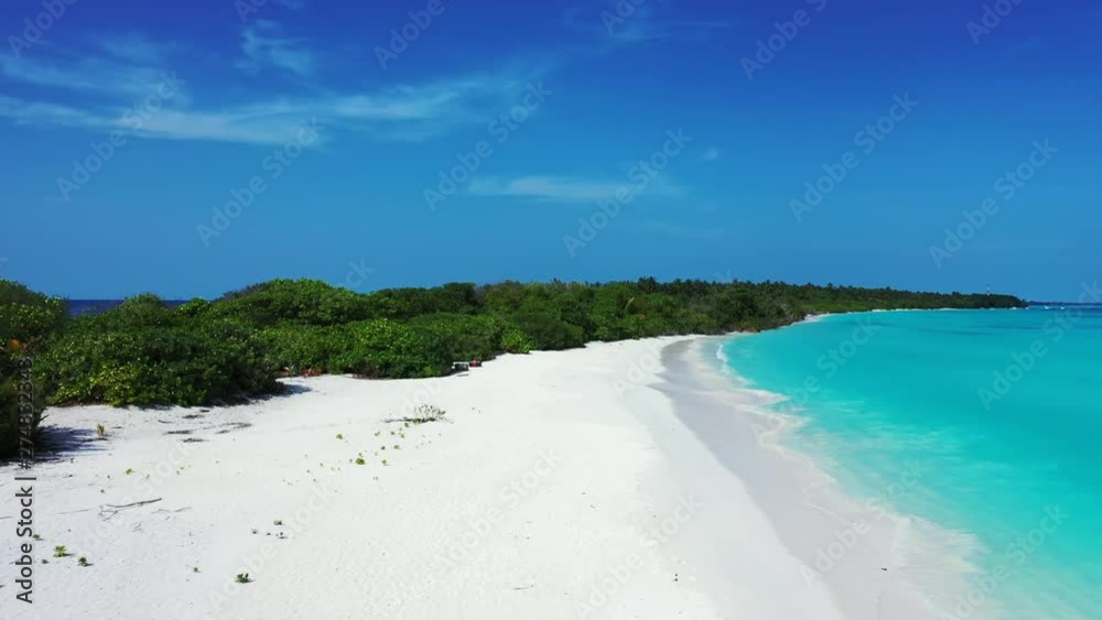 Aerial view of a white sandy beach under a blue sky. Bushes to the left. the turquoise sea to the right. In Hawaii. Dolly out Aerial view of a white sandy beach under a blue sky. Bushes to the left. the turquoise sea to the right. In Hawaii. Dolly out