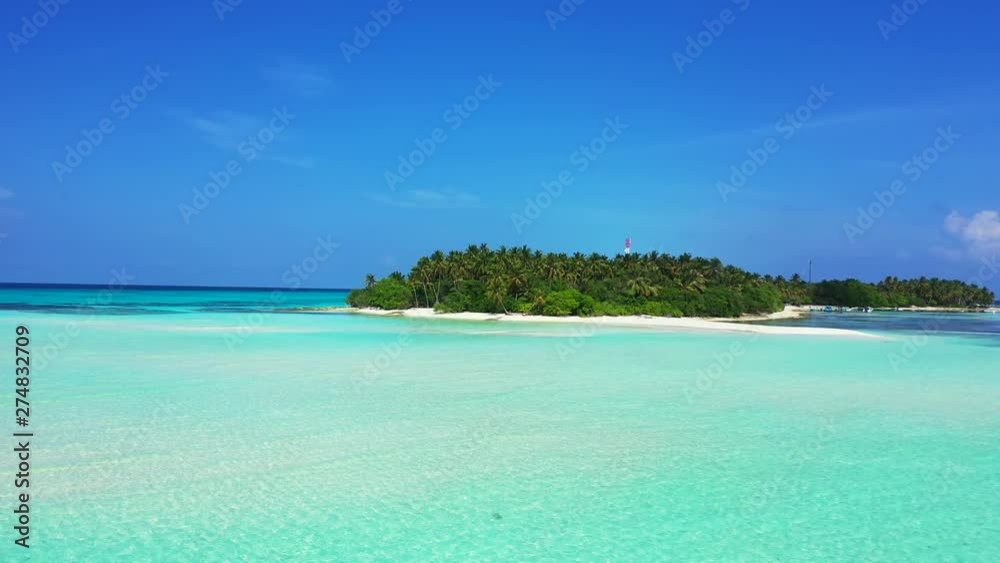 Aerial view of a tropical island in shallow turquoise water of the Dominican Sea. Under a blue sky.