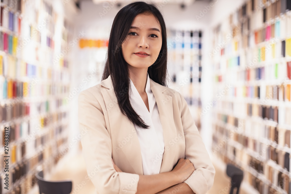 Smiling Asian business woman  looking   tablet  stay material room .young Asian business executive happy.
