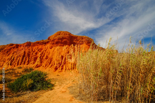 Red sandstone cliffs on the beach the Praia da Rocha Baixinha Nascente. Region Faro, Algarve, Portugal.