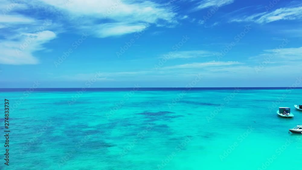 Aerial view. Boats anchoring on the left, in the turquoise water of the Philippines. under a blue sky with some clouds. Dolly in. Aerial view. Boats anchoring on the left, in the turquoise water of the Philippines. under a blue sky with some clouds. Dolly in.