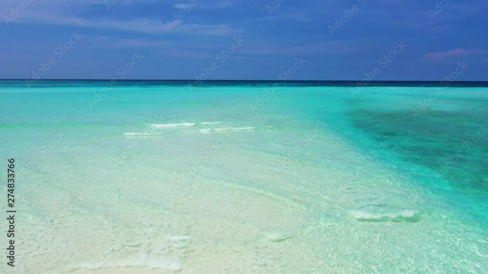 Aerial view of a sandbank in shallow turquoise water around it in the sea of Jamaica. Soft waves breaking on it, Truck right. Aerial view of a sandbank in shallow turquoise water around it in the sea of Jamaica. Soft waves breaking on it, Truck right.