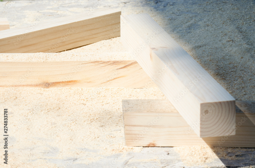 Pine wood bars lying on a pile of sawdust. Concept of carpentry, woodworking, handmade, male hobby Pine wood bars lying on a pile of sawdust. Concept of carpentry, woodworking, handmade, male hobby