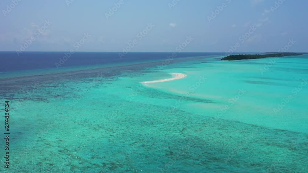 Aerial view, of a flight towards a reef where the water turns from turquoise into blue. An island is visible in the distance, in Jamaica Dolly in, truck right Aerial view, of a flight towards a reef where the water turns from turquoise into blue. An island is visible in the distance, in Jamaica Dolly in, truck right