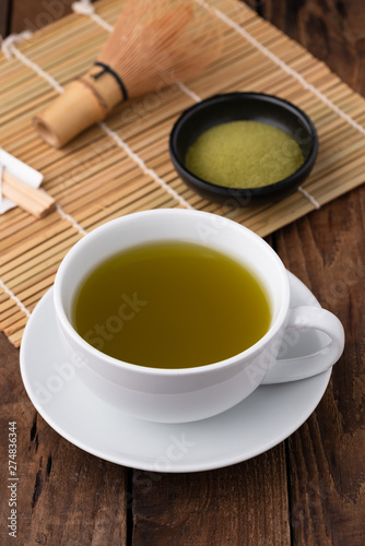hot green tea in cup on wood