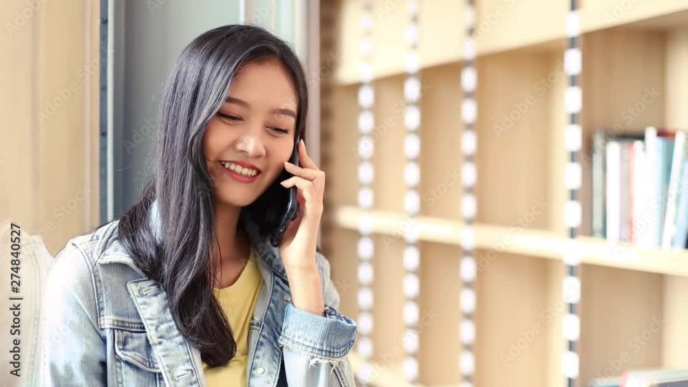 Attractive young Asian woman in a uses mobile phone .Business woman talking on the phone, smiling teen speaking on mobile, having conversation on cell Attractive young Asian woman in a uses mobile phone .Business woman talking on the phone, smiling teen speaking on mobile, having conversation on cell