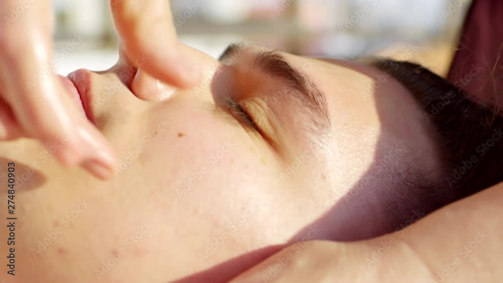 Close up of young male face having relaxing massage in spa salon Close up of young male face having relaxing massage in spa salon