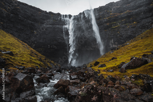 Fossa  the largest waterfall on the Faroe Islands  as seen during early spring with snow-covered mountain peaks and lush greens  Faroe Islands  Denmark  Europe  