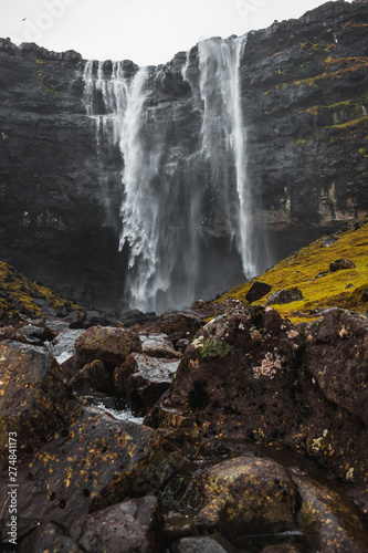 Fossa  the largest waterfall on the Faroe Islands  as seen during early spring with snow-covered mountain peaks and lush greens  Faroe Islands  Denmark  Europe  
