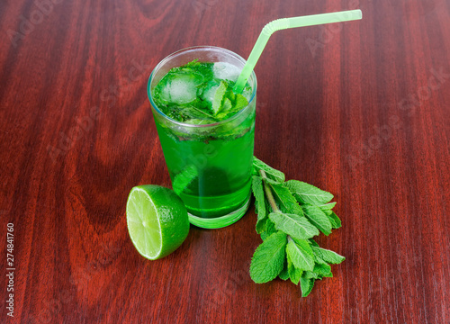 Cold mint drink, mint twigs and lime on wooden table photo