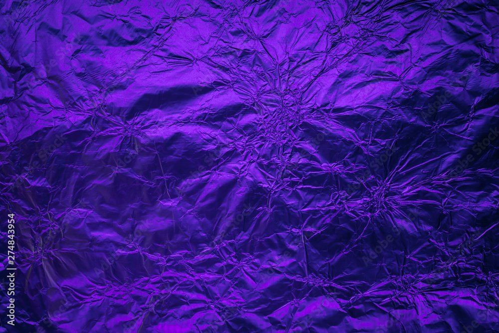 Violet purple deformed background made of illuminated foil