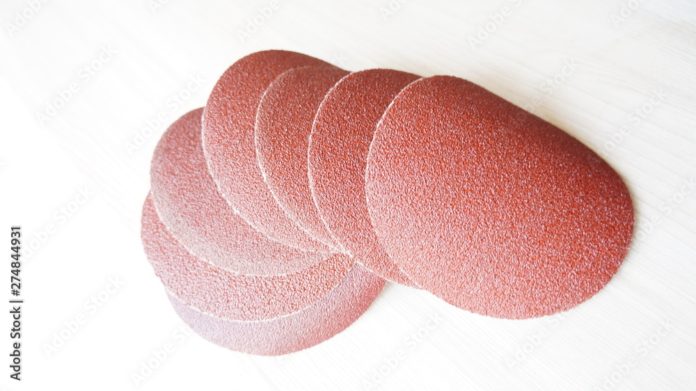 Fototapeta premium Emery paper in the form of cut circles with a fine abrasive for sanding a wooden surface