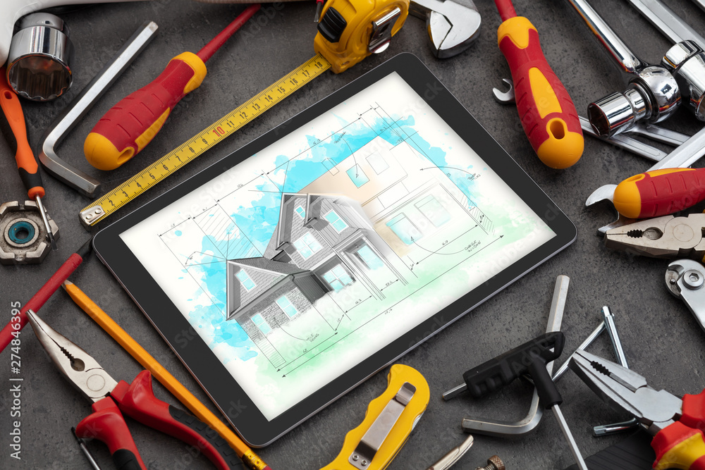 Tablet with construction tools and house plan concept
