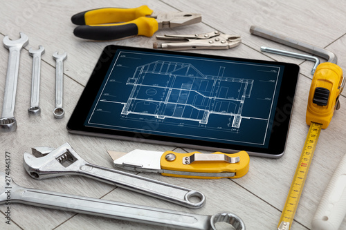 Tablet with construction tools and blueprint concept 